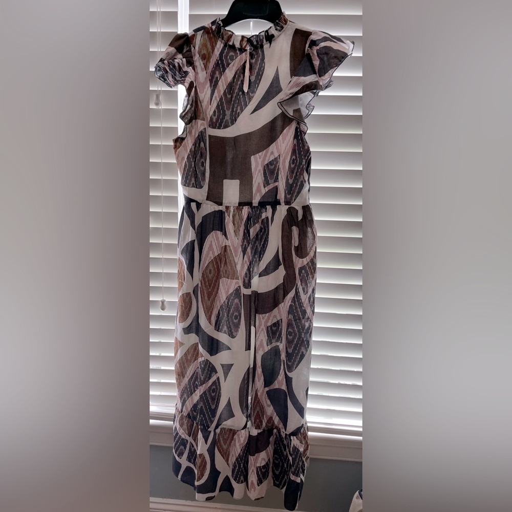 This geometrical maxi includes a ruffled neckline and flutter sleeves